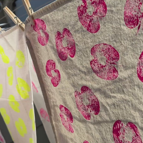 short video of handprinted textiles hanging on line in sun, blowing gently in the breeze 